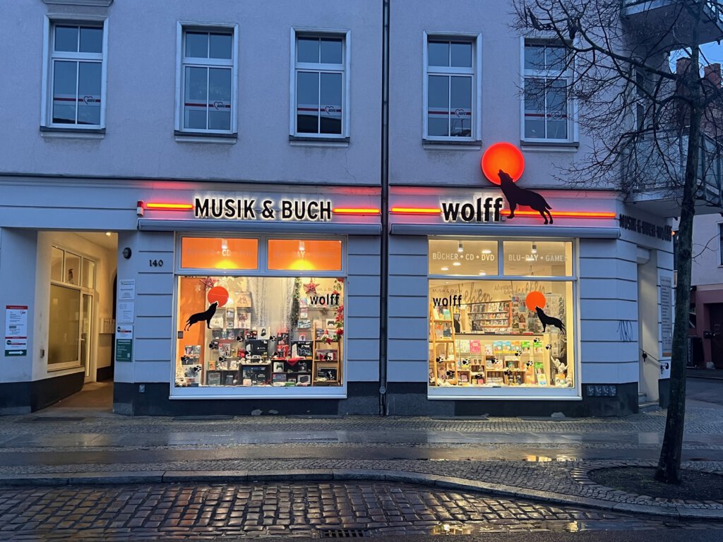 Die Buchhandlung "Musik & Buch" von Wolff in Fürstenwalde ist am Abend beleuchtet.