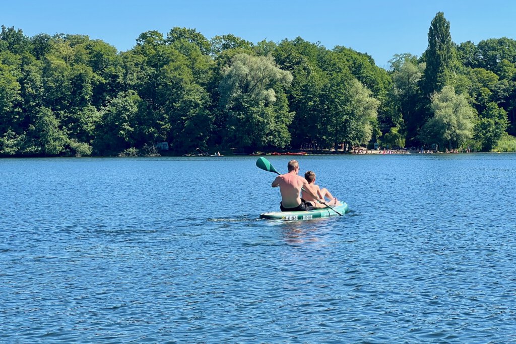 Vater und Sohn paddeln auf einem SUP auf dem Glindower See