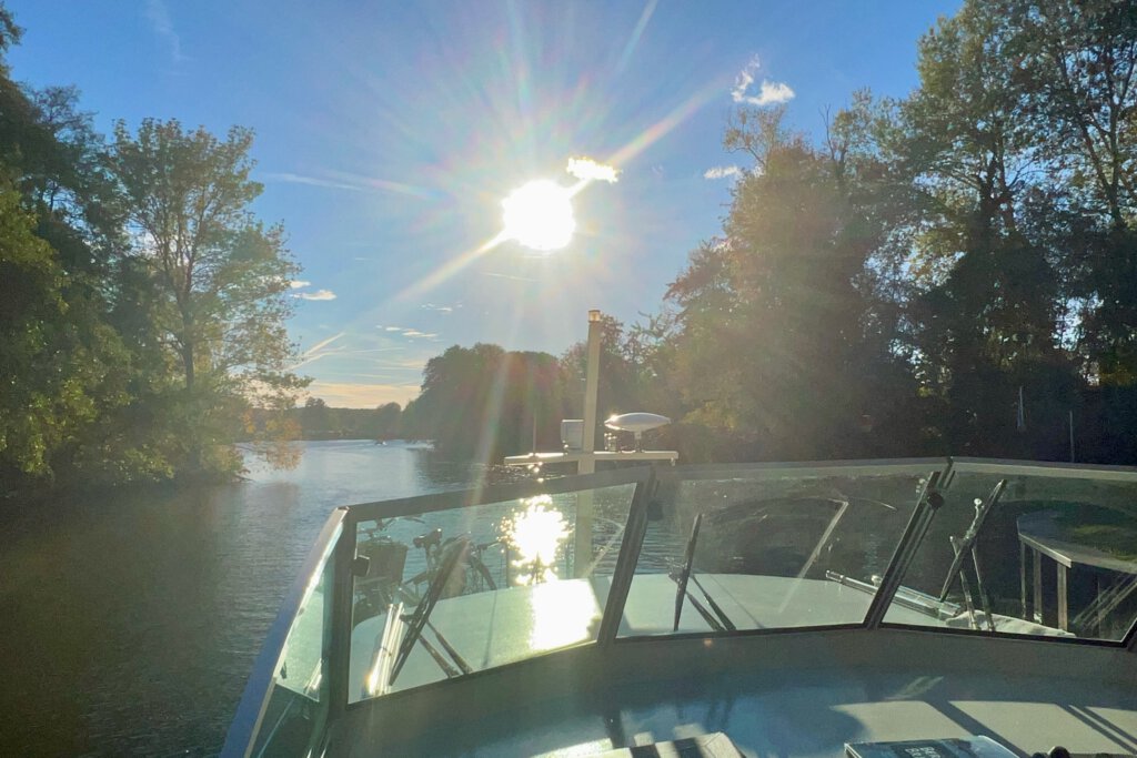Fahrt mit dem Boot durch den Strenggraben. Am blauen Himmel scheint die Sonne