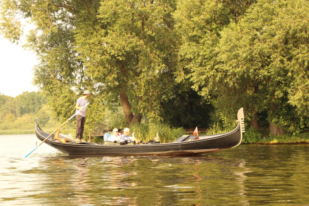 Ein Gondoliere stakt seine Gäste in einer echten venezianischen Gondel um die Inselstadt in Werder (Havel). 