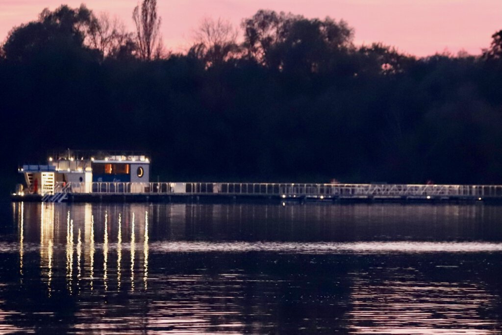 Saunasteg der Havel-Therme mit dem Saunaboot. Am Abend ist der Steg beleuchtet